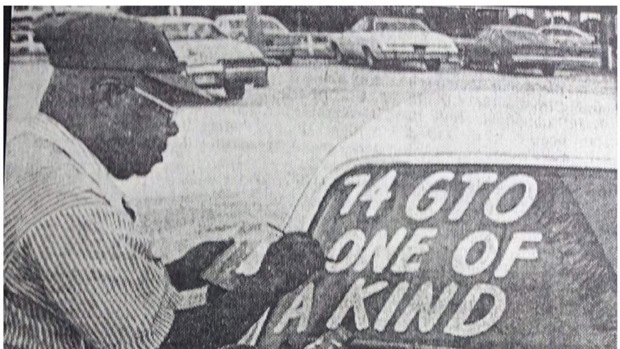 A Butler Signs craftsman hand-painting lettering on a vehicle